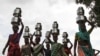 Women carry pitchers filled with water from an opening made to filter water in Thane, India.