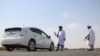 Taliban members of the Ministry for Propagation of Virtue and Prevention of Vice inspect vehicles at a checkpoint along a road on the outskirts of Herat province on October 4, 2024.