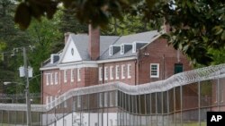 FILE - Security fences surround buildings at The Bon Air Juvenile Correctional Center, which reported at least 25 juveniles at the facility testing positive for COVID-19, April 21, 2020, in Bon Air, Virginia. 
