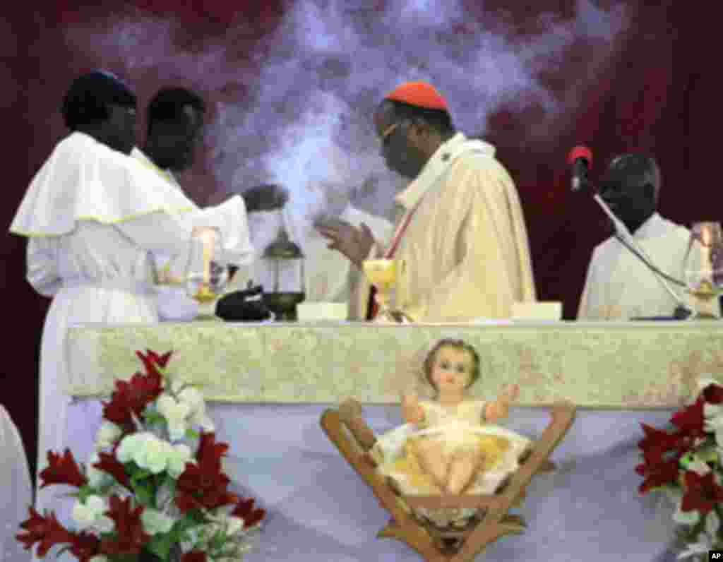 Priests pray near a figurine of the baby Jesus during a Christmas mass at Catholic Cathedral Church in the north of Khartoum, Sudan, 25 Dec 2010. (Reuters Image)