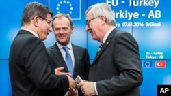 PM Turki Ahmet Davutoglu (kiri) berbicara dengan Presiden Komisi Eropa Jean-Claude Juncker (kanan) dan Presiden Dewan Eropa Donald Tusk (tengah) setelah konferensi pers di Brussels, Belgia (8/3). UNHCR hari Selasa (8/3) mengecam beberapa bagian dari kesepakatan Uni Eropa-Turki di Brussels tersebut. 