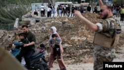 آوارگانی در حال عبور از پلی در «قاسمیه» هستند که جنوب لبنان را به بقیه کشور متصل می‌کند؛ پلی که پیش‌تر در جریان حمله اسرائیل هدف قرار گرفته بود