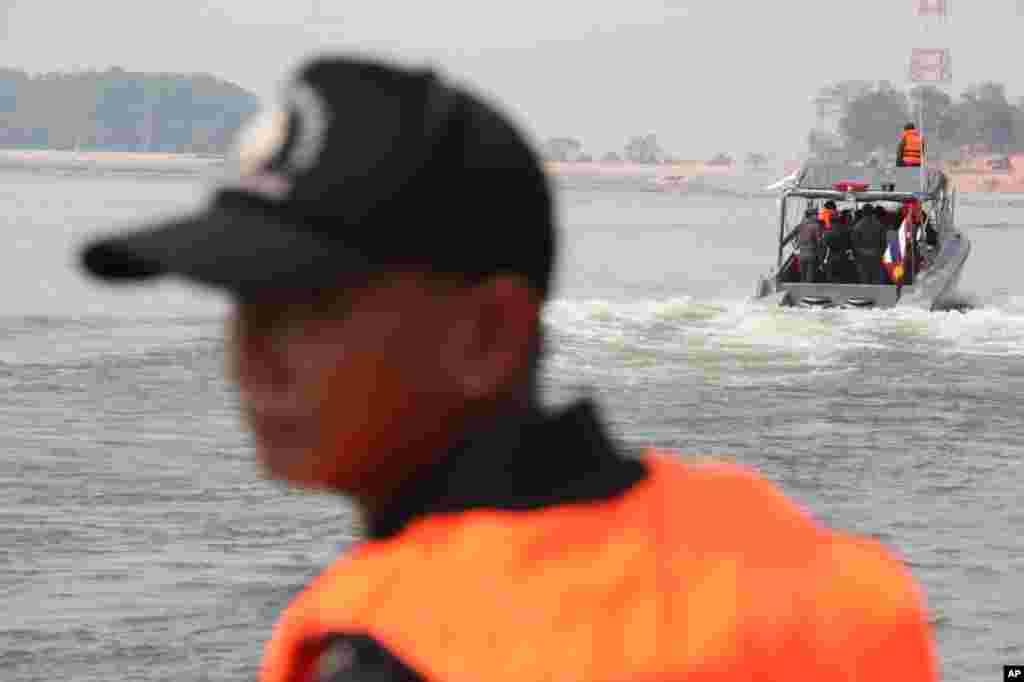 A patrol boat officer escorts Chinese delegation on the Mekong River. (VOA - D. Schearf)