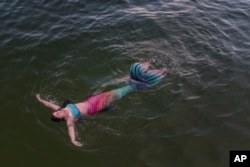 Lauren Metzler, founder of Sydney Mermaids, swims at Manly Cove Beach in Sydney, Australia, Thursday, May 26, 2022. (AP Photo/Mark Baker)