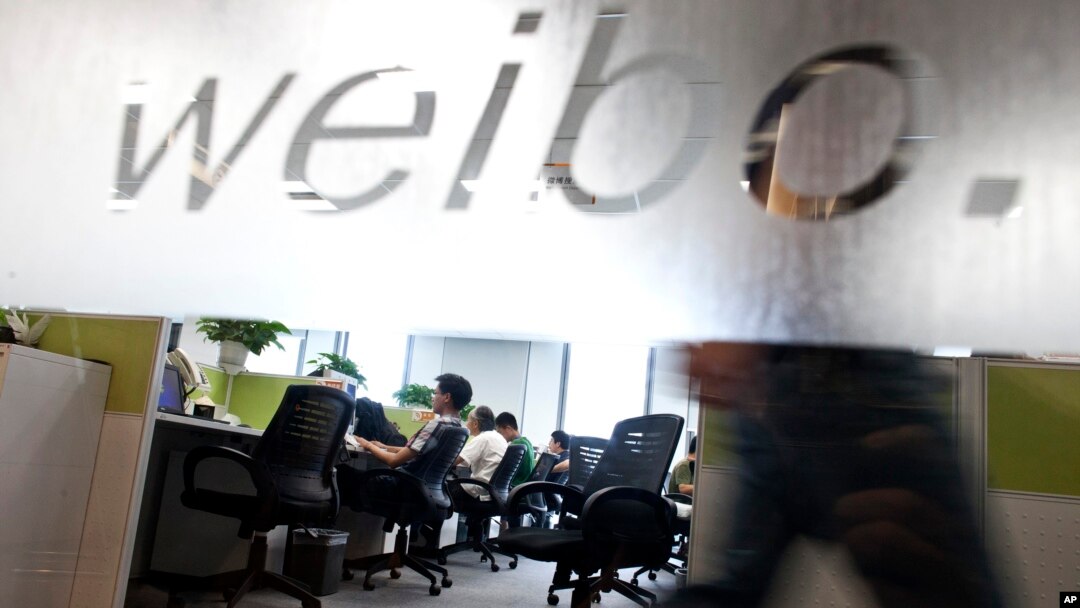 FILE - Employees work at their desks at a Sina Weibo office in Beijing. 