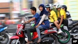 Perempuan Aceh membonceng sepeda motor di Lhokseumawe (7/1). (AP/Rahmat Yahya)