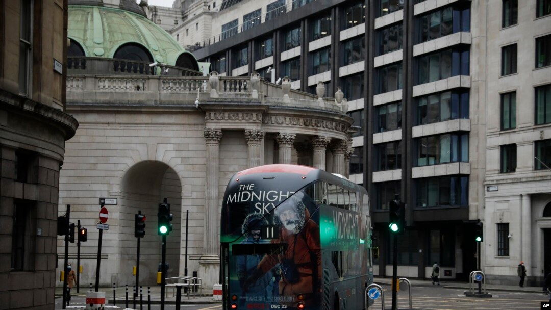 A bus drives through the City of London financial district in London, Jan. 5, 2021, on the first morning of England entering a third national lockdown since the coronavirus outbreak began. 