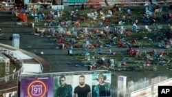 FILE - Personal belongings and debris litter festival grounds across the street from the Mandalay Bay resort and casino in Las Vegas following a mass shooting at the venue, Oct. 3, 2017.