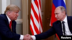 ARCHIVO - El presidente estadounidense Donald Trump y el presidente ruso Vladimir Putin se dan la mano mientras se reúnen en Helsinki, Finlandia, el 16 de julio de 2018.