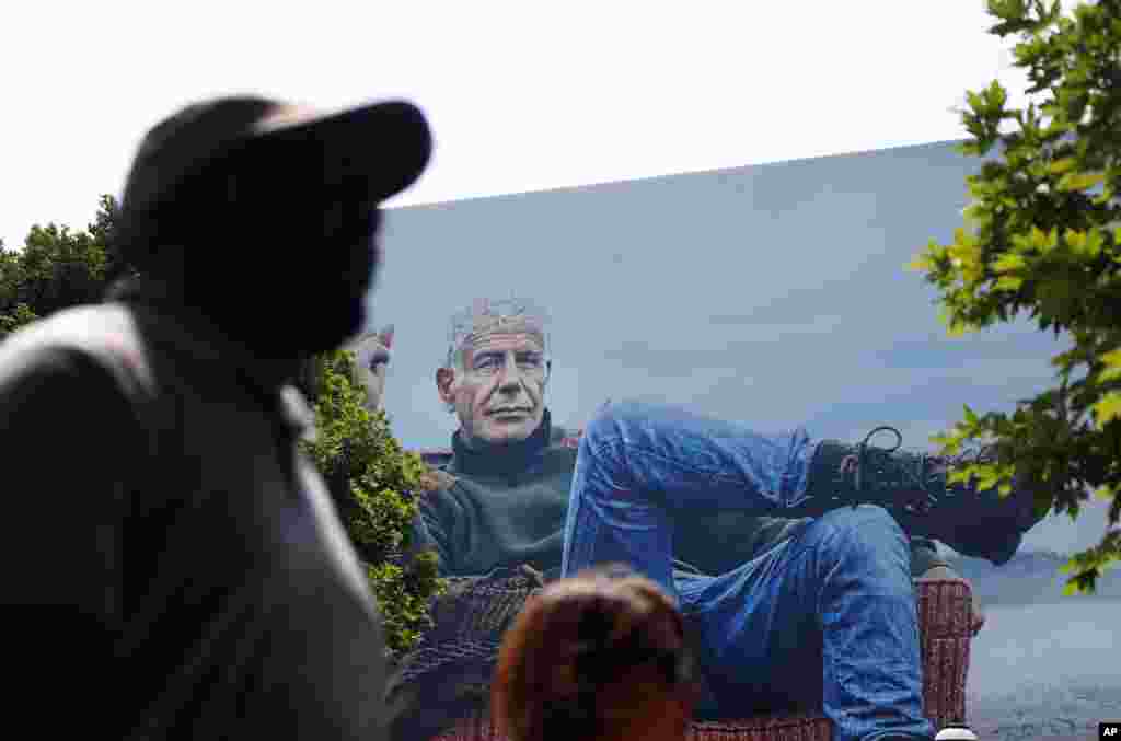 People walk past a billboard for the CNN television show "Parts Unknown" with American celebrity chef Anthony Bourdain, Friday, June 8, 2018 in Atlanta, Georgia.