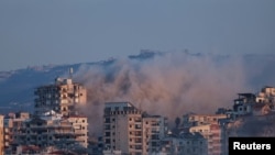 Asap tebal mengepul di Lebanon selatan setelah serangan udara Israel seperti yang terlihat dari Tyre, Lebanon (25/9). 