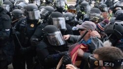 Policijski službenici Kapitola u opremi za borbu protiv nereda potiskuju demonstrante koji pokušavaju razbiti vrata američkog Kapitola u srijedu, 6. januara2021. u Washingtonu. (AP Photo / Jose Luis Magana)