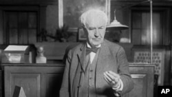 File - Thomas Edison presses a button in West Orange, N.J., in 1928. The button turns on street lights in Seattle. (AP Photo)