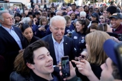 FILE - Democratic presidential candidate Joe Biden takes selfies with supporters at a "Get out the Vote" event in Sterling, Va., Nov. 3, 2019.