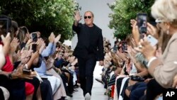 Designer Michael Kors is applauded on the runway after his collection was modeled during Fashion Week in New York, Sept. 11, 2019.