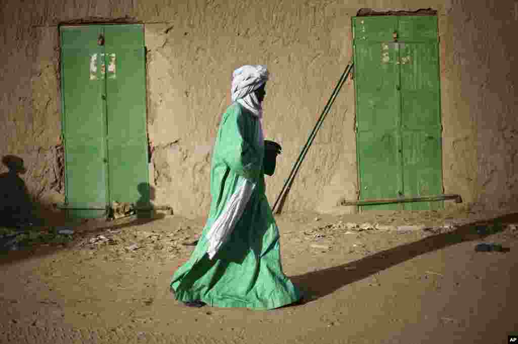 A Malian man walks between doors of closed shops in Gao, northern Mali, February 5, 2013. 