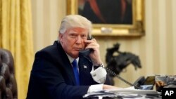 FILE - President Donald Trump speaks on the telephone in the Oval Office of the White House in Washington, Jan. 28, 2017. On Wednesday, Trump spoke with Saudi King Salman.