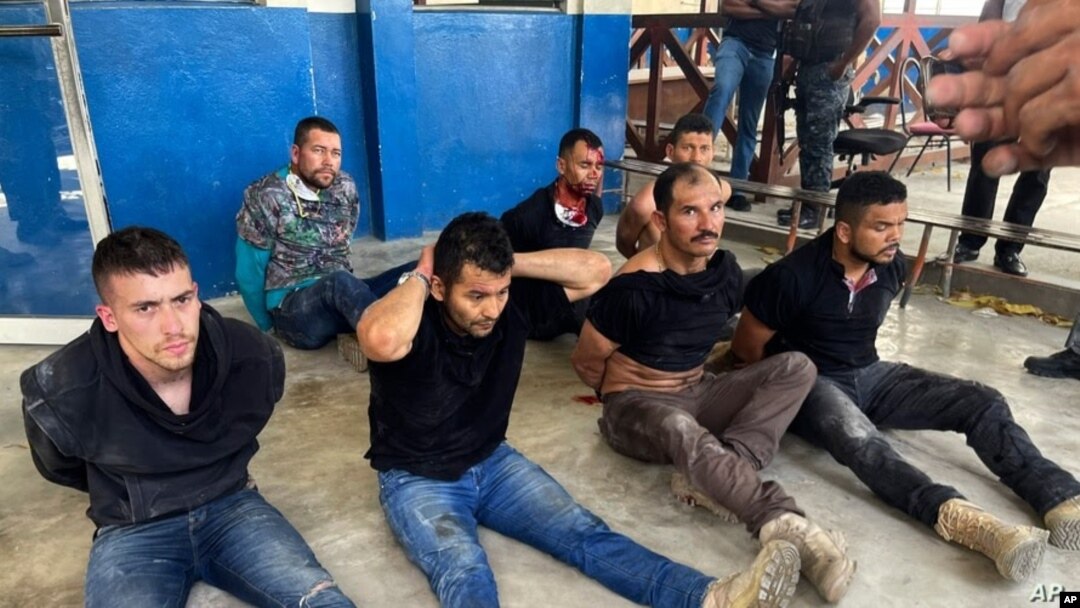 Los sospechosos del asesinato del presidente de Haití, Jovenel Moise, sentados en el piso y esposados ​​después de ser detenidos, en la Dirección General de la policía en Puerto Príncipe, el 8 de julio de 2021.