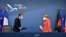 German Chancellor Angela Merkel, right, and French President Emmanuel Macron prepare to address a media conference at the end of an EU summit in Brussels, July 21, 2020. 