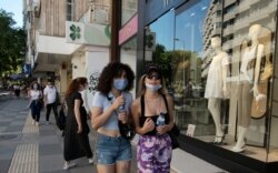 FILE - People wearing face masks to protect against the spread of coronavirus, walk a in popular shopping street, in Ankara, Turkey, June 27, 2020.