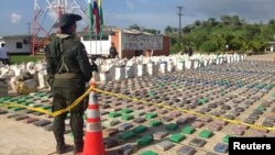 콜롬비아 경찰이 15일 몰수한 8톤 분량의 코카인 마약을 지키고 서 있다.