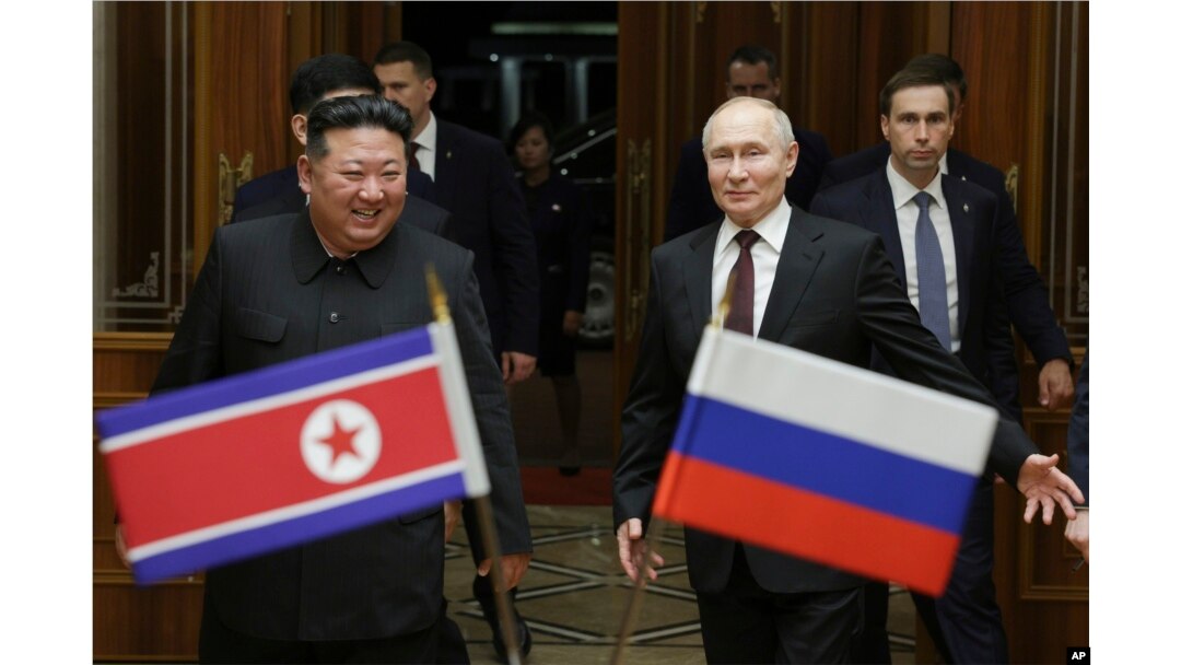 Presiden Rusia Vladimir Putin, kanan, dan pemimpin Korea Utara Kim Jong Un tersenyum selama pertemuan mereka di Bandara Internasional Pyongyang Sunan di luar Pyongyang, Korea Utara, 19 Juni 2024. (Foto: via AP)