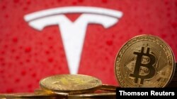 En esta ilustración, se ven representaciones de la moneda virtual Bitcoin frente al logotipo de Tesla. [Foto de archivo]