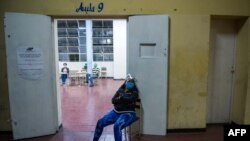 Una trabajadora electoral se sienta mientras espera que los votantes lleguen a un centro electoral en Caracas, el 6 de diciembre de 2020 durante las elecciones legislativas de Venezuela.