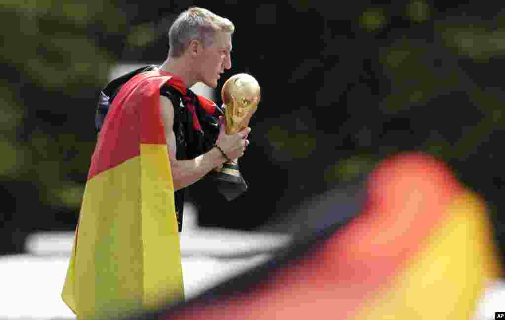 Bastian Schweinsteiger mencium piala ketika merayakan kemenangan tim nasional sepakbola Jerman di Piala Dunia di Berlin, 15 Juli 2014.