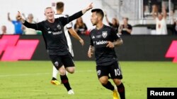 Wayne Rooney (kiri) merayakan gol yang dicetak oleh rekan setimnya, Luciano Acosta (10) saat melawan tim Vancouver Whitecaps di stadion Audi Field di Washington DC, Sabtu (14/7).