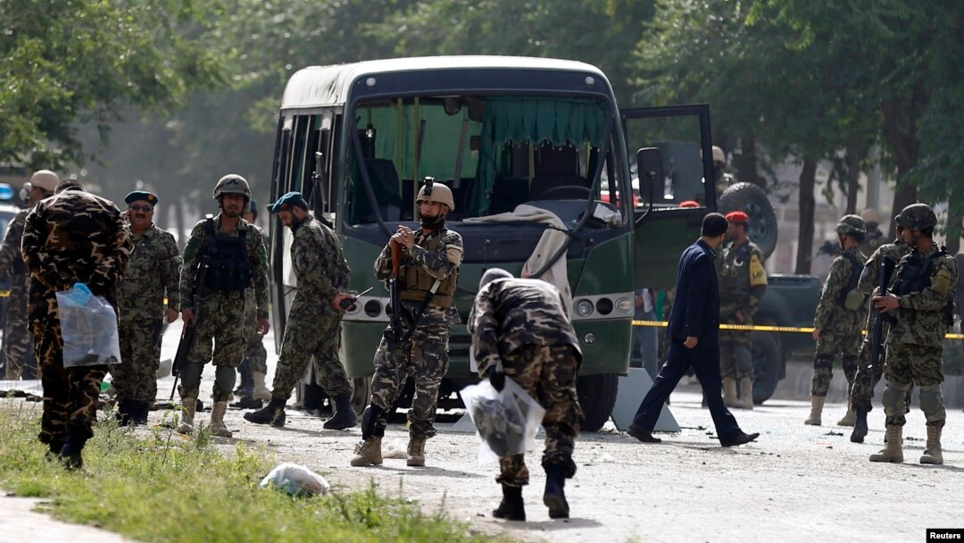 Para petugas memeriksa lokasi serangan bom bunuh diri yang menarget sebuah bus angkatan udara Afghanistan di Kabul (2/7). Delapan perwira dilaporkan tewas dalam insiden tersebut.