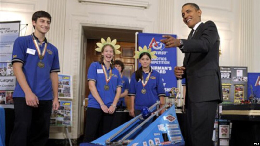 Presiden Barack Obama memperhatikan robot pemain sepak bola yang dirakit oleh tim pelajar dari negara bagian Pennsylvania.