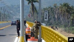 ARCHIVO - La policía y el ejército custodian el recién construido puente Coyuca cerca de la ciudad de Coyuca de Benítez en el estado de Guerrero, México, el jueves 4 de diciembre de 2014.