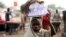 A girl sells drinking water packed in small plastic bags on a street in the northern city of Maiduguri, Nigeria, August 2009.