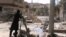Free Syrian Army fighters drop shell into a firing tube, in Damascus countryside, Syria, Mar 24,2013 (Ugarit News via AP video)