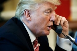 FILE - In this June 27, 2017, photo, President Donald Trump talks on the telephone in the Oval Office of the White House.