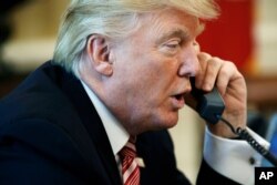 FILE - In this June 27, 2017, photo, President Donald Trump talks on the telephone in the Oval Office of the White House.