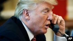 FILE - In this June 27, 2017, photo, President Donald Trump talks on the telephone in the Oval Office of the White House.