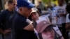 پدر لیری آلباگ با تصویر دخترش در تجمع خانواده‌های گروگان‌ها در تل آویو. 