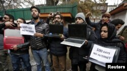 FILE PHOTO: Kashmiri journalists display laptops and placards during a protest demanding restoration of internet service, in Srinagar, November 12, 2019. 
