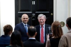 FILE - John Bolton, President Donald Trump's national security adviser, right, is welcomed at Downing Street by Britain's Chancellor of the Exchequer Sajid Javid in London, Britain, Aug. 13, 2019.