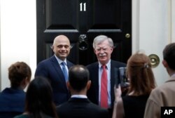 FILE - John Bolton, President Donald Trump's national security adviser, right, is welcomed at Downing Street by Britain's Chancellor of the Exchequer Sajid Javid in London, Britain, Aug. 13, 2019.