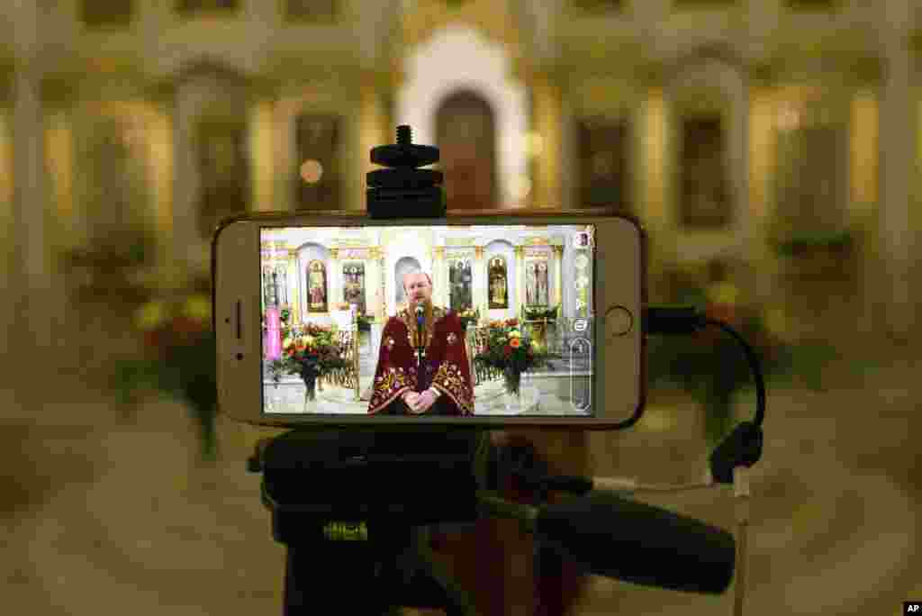 Un sacerdote de la Iglesia Ortodoxa habla a los creyentes durante una transmisión en vivo en una iglesia vacía en Moscú, Rusia. Solo unos pocos sacerdotes acompañados por voluntarios realizaron el servicio religioso mientras los fieles acataban la prohibición de unirse a las celebraciones religiosas de la Pascua.