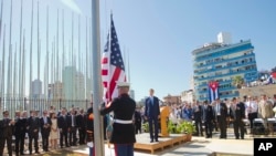 Secretary of State John Kerry and others watch as U.S. Marines raise the U.S. flag over the newly reopened embassy in Havana, Cuba.