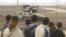 Palestinians stand close to the fence as an Israeli tank is seen on the border between Israel and southern Gaza Strip, November 23, 2012.