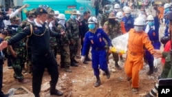 In this photo provided by Preah Sihanouk Provincial Authority, rescuers carry the body of a victim at the site of a building collapse, Monday, June 24, 2019, in Preah Sihanouk province, Cambodia.