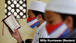 Siswa Muslim mengenakan masker wajah di tengah penyebaran COVID-19, saat membaca Alquran di Masjid Al-Kautsar Daarul Qur'an selama bulan suci Ramadhan, di Bogor, Jawa Barat, 9 Mei 2020 . (Foto: Reuters/Willy Kurniawan)