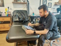 Lokesh Verma conceptualizes a memorial tattoo for a client. (Anjana Pasricha/VOA)