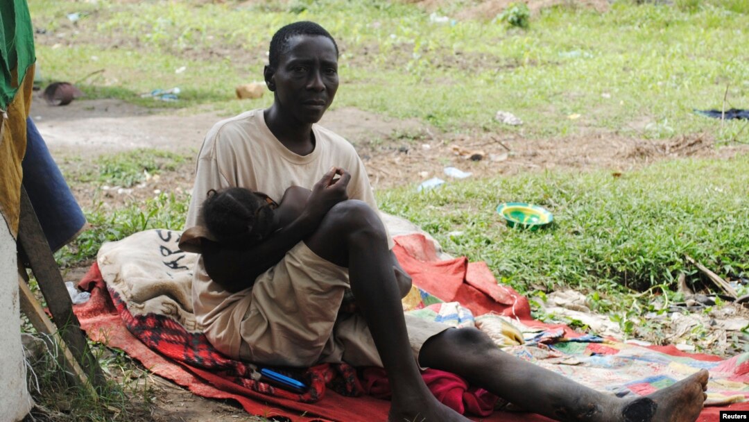 Penderita Ebola, James Flomo menggendong anaknya di Monrovia, Liberia, setelah istri James meninggal akibat ebola tiga hari sebelumnya (foto: dok).