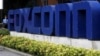 FILE - A security guard stands at the entrance of the Foxconn complex in the southern Chinese city of Shenzhen.